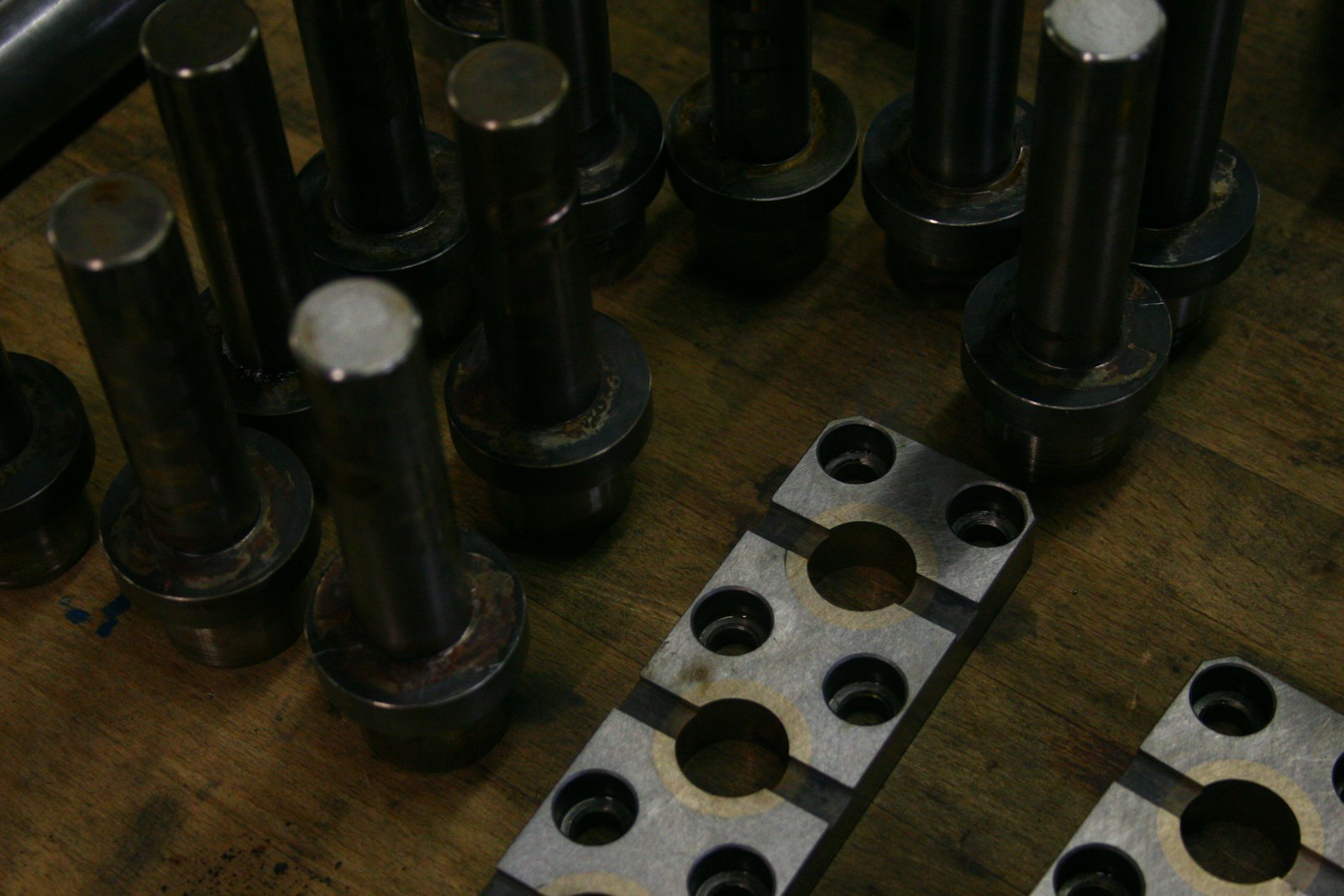 Metal components on a workbench, showing holes, shapes and structural details